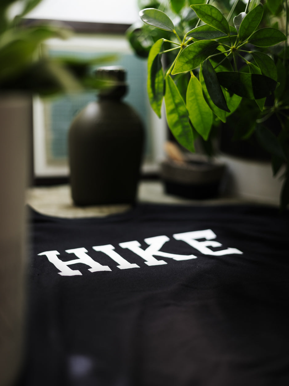 A closeup photo of The Hike T - with camping accessories and plants nearby.