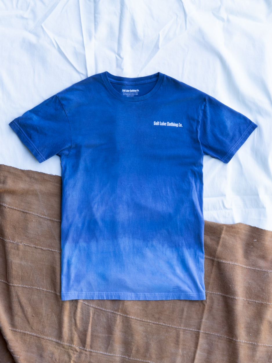 The Good Company T Azure Dip Dye set on mud cloths that create an abstract landscape of red rock and clouds.