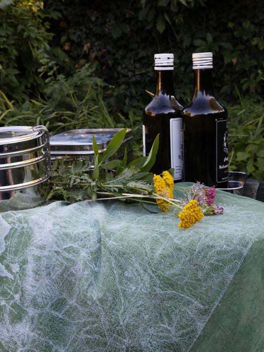 Wasatch Topographic Bandana on a cooler, with flowers, food containers, and bottles ready for a picnic.
